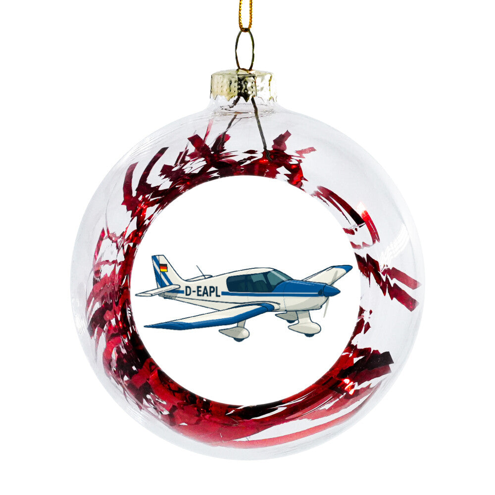 Weihnachtskugel mit einem Flugzeug  abgebildet und roten Folienstreifen